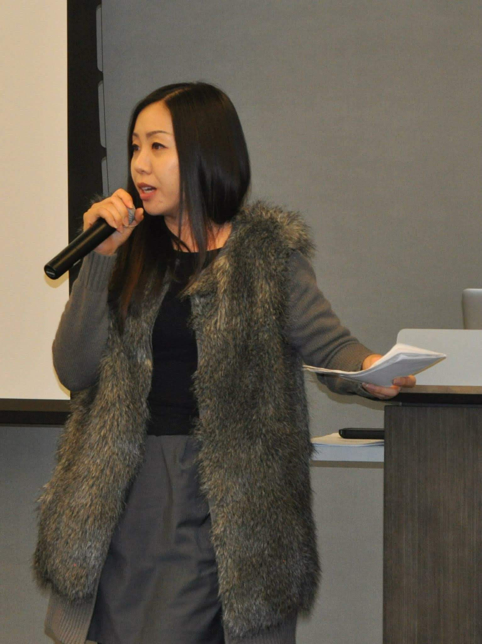 Portrait of Angie Lee speaking with a microphone